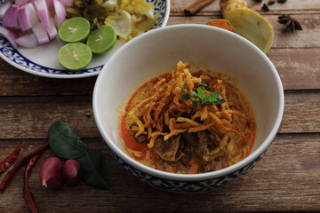 Local northern Thai food Egg noodle curry with beef on wood background
