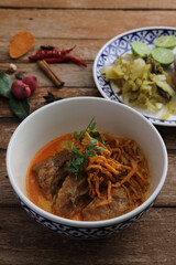 Local northern Thai food Egg noodle curry with pork ribs on wood background