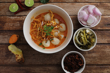 Local northern Thai food Egg noodle curry with meatballs on wood background