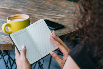 Woman flipping notebook in cafe