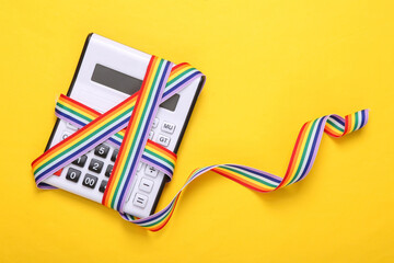 Calculator with LGBT rainbow ribbon tape on yellow background.
