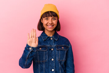 Young mixed race woman isolated on pink background smiling cheerful showing number five with fingers.