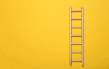 Wooden staircase on yellow background.
