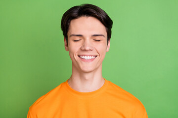 Fototapeta premium Photo of young dreamy happy man closed eye smile good mood positive isolated on green color background