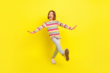 Full body photo of cheerful young positive small girl dance funny funky mood isolated on yellow color background