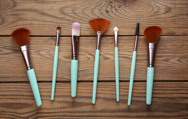 Set of makeup brushes on a wooden background