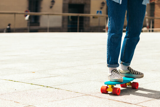 Anonymous girl skating on a city square