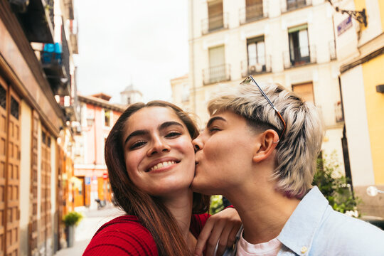 Selfie photo of two beauty girls kissing on the cheek