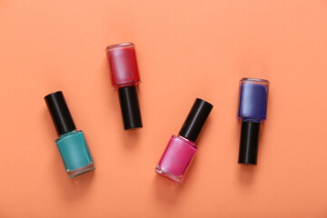 Obraz premium Bottles of colored nail polish on orange background. Top view