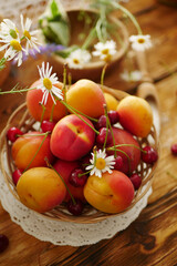 Summer ripe fruits peaches, apricots, cherries on a wooden table. Summer food background, copy space