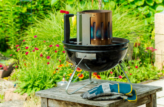 Barbecue grill, Preparation for food grilling over a fire. Kindling coals. Chimney and lighting it. Using coal chimney starter, lighting the flame on the grill grate. terrace and garden Background