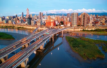 Obraz premium Top view of Zhongxing Bridge spanning Tamsui River & connected to the riverside Huanhe Expressway with crowded buildings in Ximending Downtown & 101 Tower standing in background in vibrant Taipei City