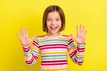 Photo of cheerful young charming little girl hold hands good mood smile isolated on yellow color...