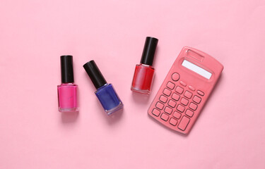 Obraz na płótnie Canvas Bottles of colored nail polish and calculator on pink background. Top view