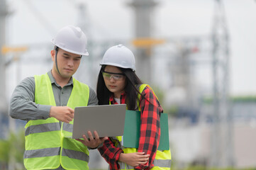 Two engineer working at power plant,Work together happily,Help each other analyze the...