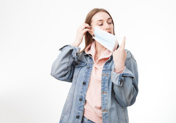 Young woman putting on a medical mask isolated on white background.