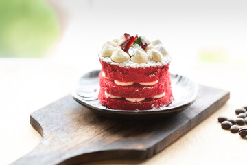 Red Velvet homemade cake decorated with cream with vintage plate on on burned wood. Dessert or bakery with Tea or Coffee time. Home made Cake concept.
