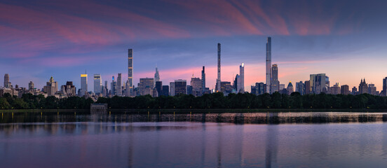 New York City skyline. Midtown Manhattan skyscrapers from Central Park Reservoir at Dusk. Evening view of billionaires' row super tall luxury buildings