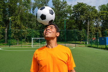 Brazilian soccer player trains and improves soccer ball control on sport ground