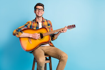 Photo of cute charming gentleman wear checkered shirt glasses sitting playing guitar empty space...