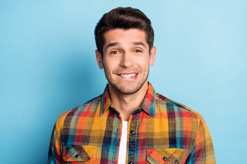 Fototapeta premium Portrait of attractive cheerful brunette guy wearing checked shirt thinking biting lip deciding isolated over bright blue color background