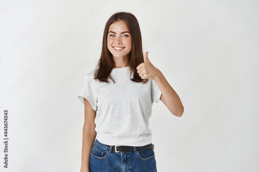 Wall mural satisfied female showing thumbs-up, say yes, recommending product, praising something cool, standing