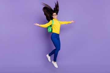 Full length photo of positive active young woman jump up fly hair smile good mood isolated on...