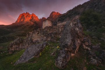 Ingushetia, Land Of Towers And Legends. One Of The Ancient Tower Complexes At The Foot Of Mount Tsey-Loam On The Mountain Pass Of The Same Name.Tsey-Lom Peak At Sunrise.Erzi, North Caucasus, Russia. - 443674787