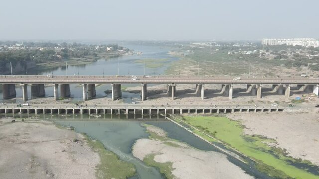 Cars driving onto Bridge towards City Skyline , Aerial birds eye view tilt up