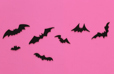 Halloween background, decorations and scary concept. Black bats fly over pink background