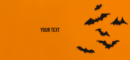 Halloween background, decorations and scary concept. Black bats fly over orange background, Copy space