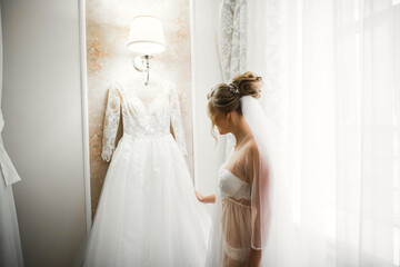 Luxury bride in white dress posing while preparing for the wedding ceremony