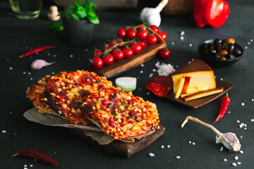 Pizza. Mini italian pizzas with cheese, pepper and tomatos. Pizza on wooden plate. - obrazy, fototapety, plakaty
