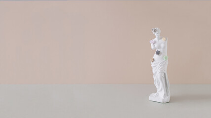Creative layout with the sculpture of an antique Venus on the pastel beige background.  Concept art with a minimalist aesthetic. © Nataliya
