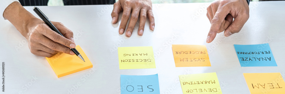 Poster Two creative business people meeting and planning use note on desk to share idea, Analysis data chart and graph with teamwork strategy brainstorming in office