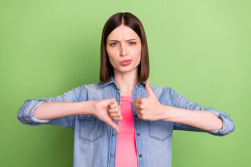 Photo of young girl happy positive smile show thumb-up thumb-down like dislike isolated over green...
