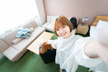 ホテルの部屋で自撮り写真（セルフィー）を撮る女性