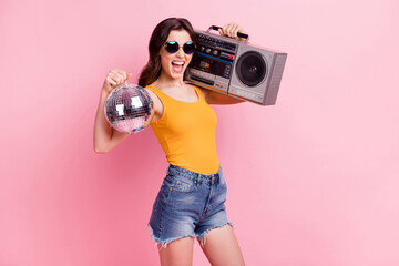 Photo of impressed horned young lady dressed yellow tank-top dark glasses holding boom box disco...