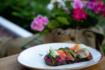 Sandwich with salmon and cucumber on black bread