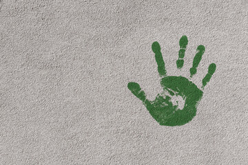 Gr&uuml;ner Handabdruck an einer Hausfassade