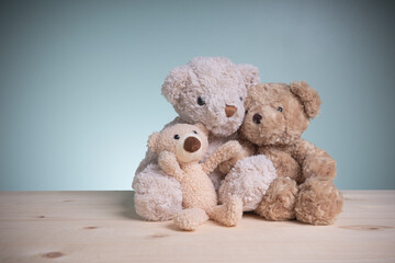 Concept family, love, and valentines festival. Family hug happy. Brown teddy bears sitting huggy show love, happiness on an old wooden table with copy space.