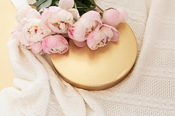 Styled composition with pink tulips on gold background. Flat lay floral frame and white textile. Border top view.