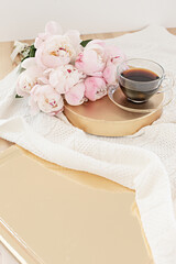 Styled composition with pink tulips on gold background. Floral frame and white textile. Border top view.