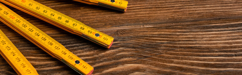 top view of folding ruler on wooden table, labor day concept, banner