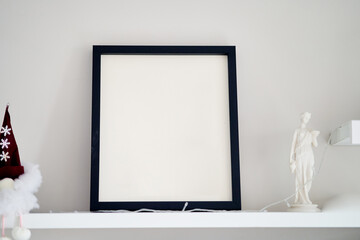 Blank wooden photo frame stands in the interior on a white background. Mockup poster frame close up in home interior.