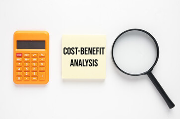 Calculator, magnifying glass and notepad wirtten Cost-Benefit Analysis. cost-benefit analysis is a systematic process that businesses use to analyze during decision making