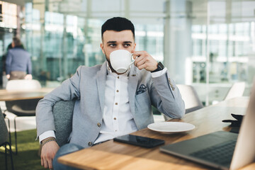 Thoughtful businessman drinking coffee during break