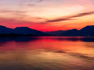 Naklejka premium Beautiful view after sunset at lake with background mountains and reflections