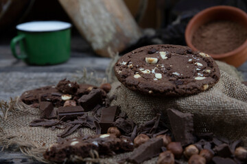 Chocolate cookies with hazelnuts , cocoa and pieces of dark chocolate on the rustic kitchen table