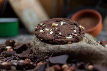 Chocolate cookies with hazelnuts , cocoa and pieces of dark chocolate on the rustic kitchen table